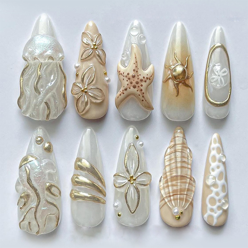 Luxury ocean press-on nails with 3D jellyfish, starfish, seashells, pearls, and gold accents. Elegant reusable nails for beach and summer looks.
