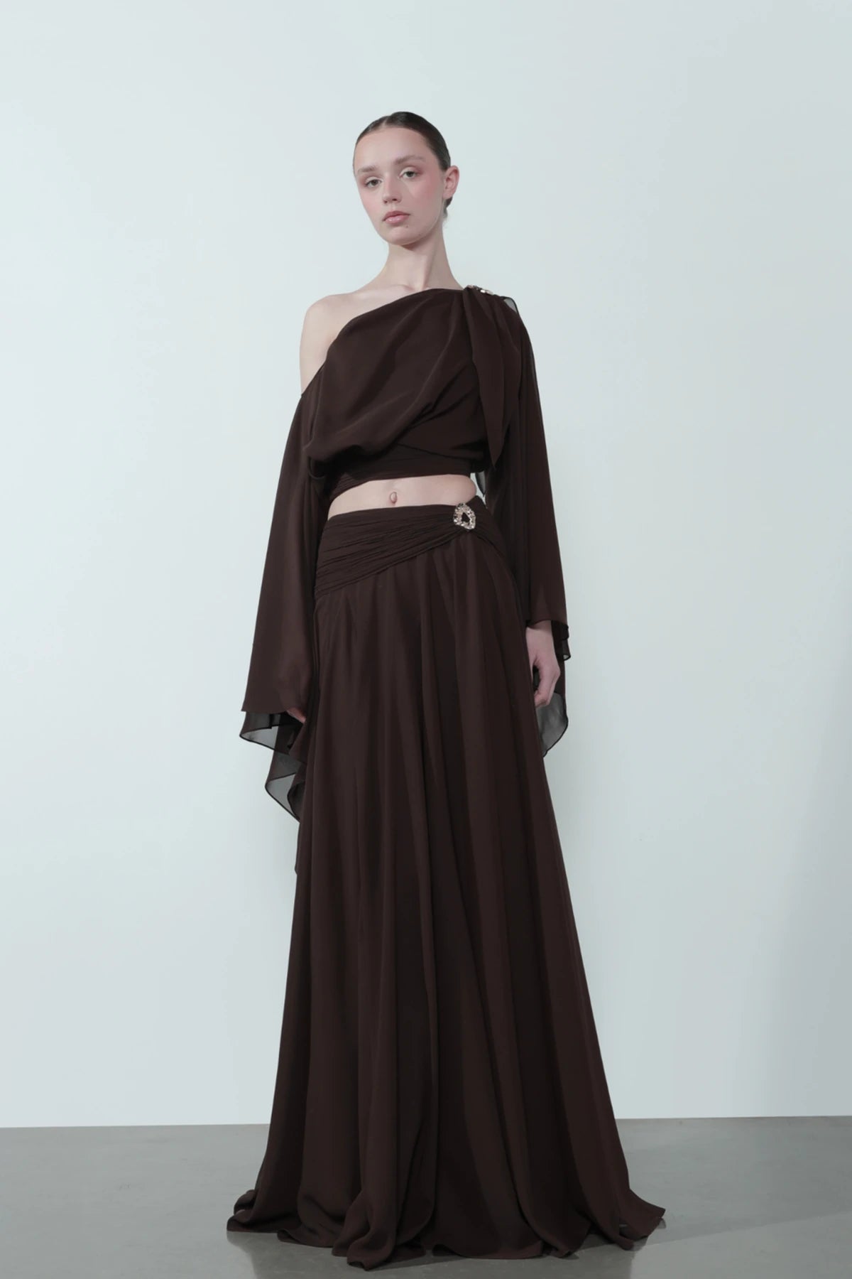 Chocolate Brown Maxi Set. Dramatic one-shoulder top, a flowing maxi skirt—the perfect sophisticated ensemble for your next upscale evening event.