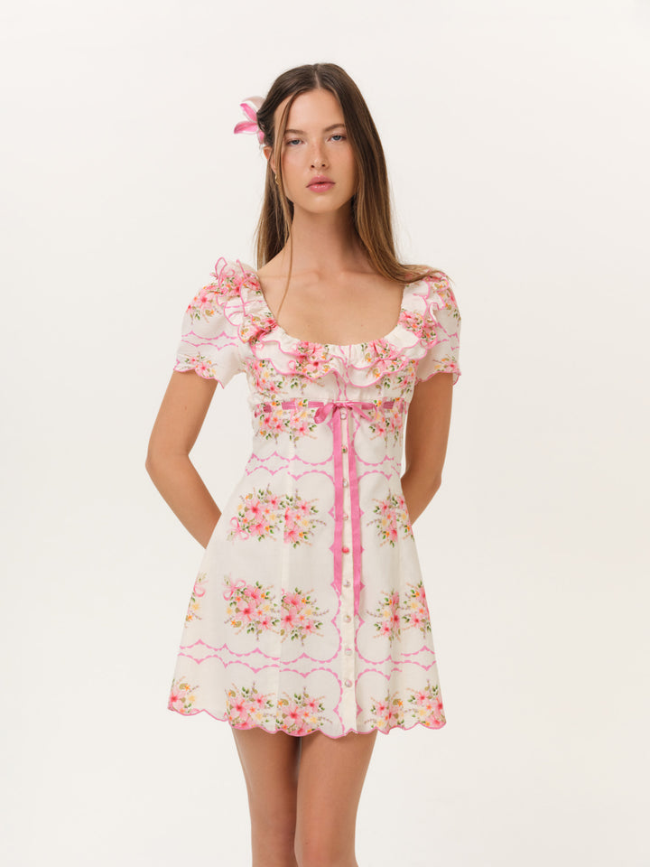 Pink Floral Ruffle Mini Dress.Delicate ribbon tie, and a charming floral print—the perfect feminine choice for your next sunny getaway.