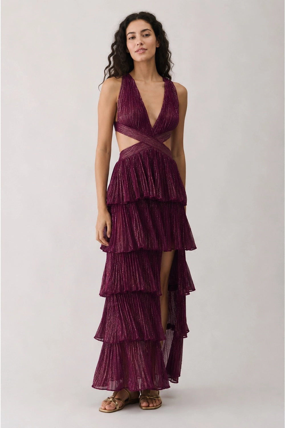 Plum Shimmer Tiered Maxi Dress. Dramatic tiered layers, and chic side cut-outs—the ultimate statement piece for your next upscale evening event.