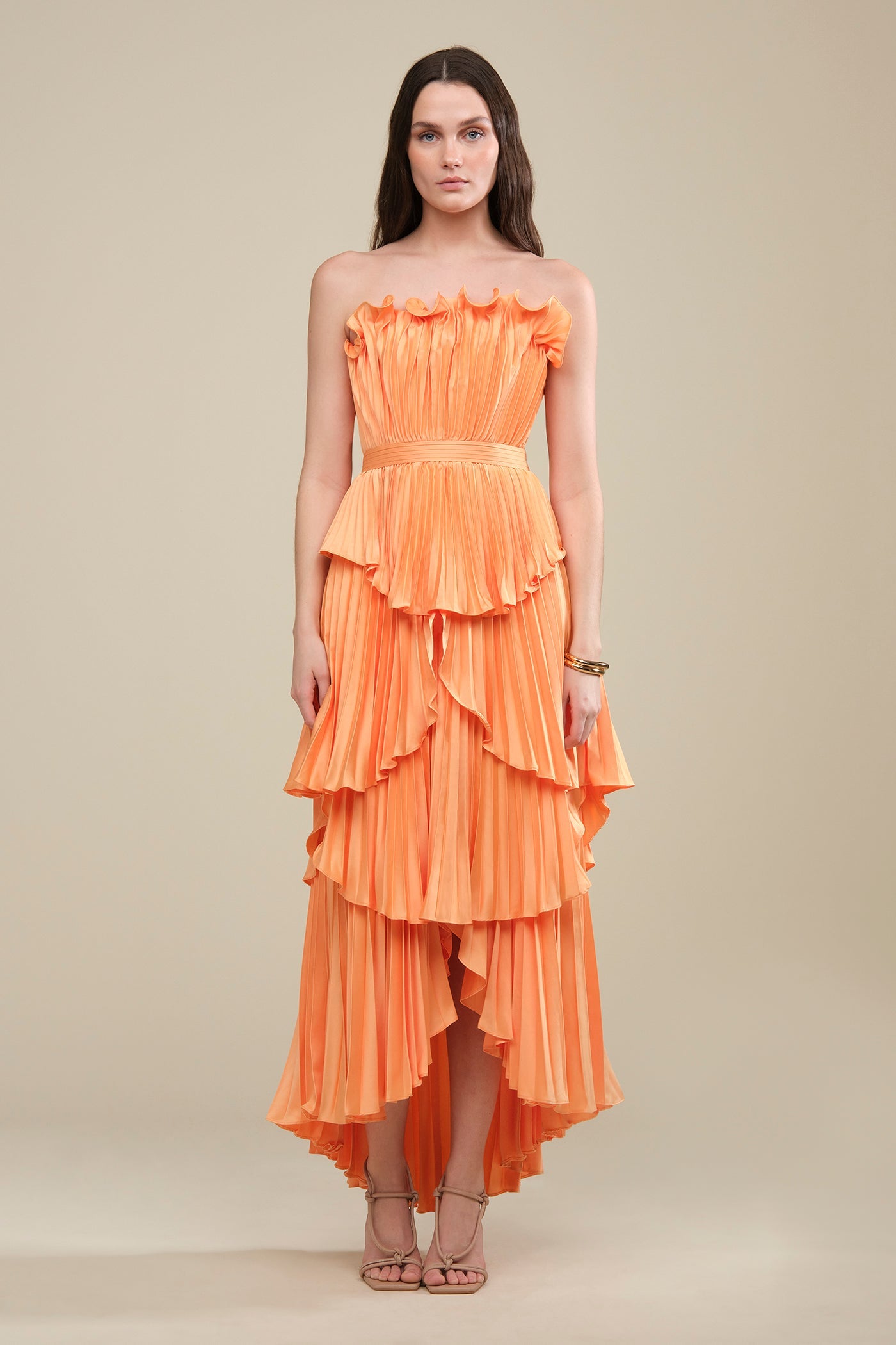 Tiered Pleated Strapless Maxi Dress. Featuring a vibrant hue, delicate ruffle-edge bodice, and a dynamic high-low tiered skirt perfect for elegant summer soirées.