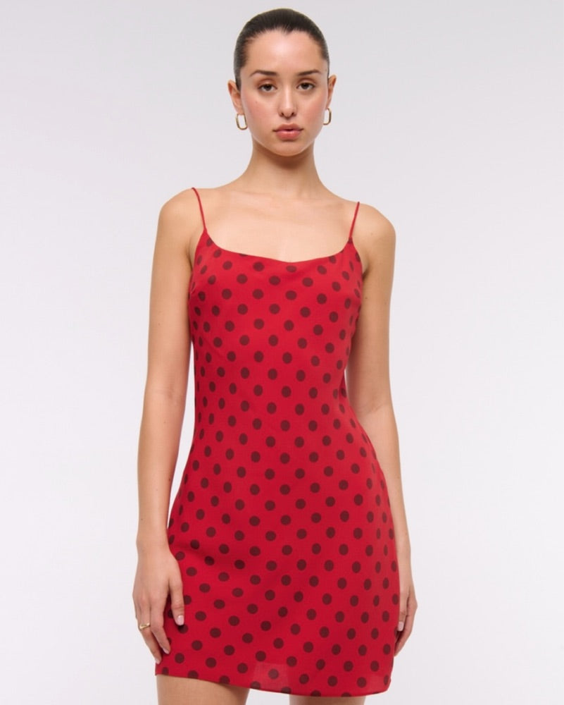Classic Red Polka Dot Mini Dress. Flattering spaghetti straps, and a chic mini silhouette, this piece is the ultimate vacation wardrobe essential.