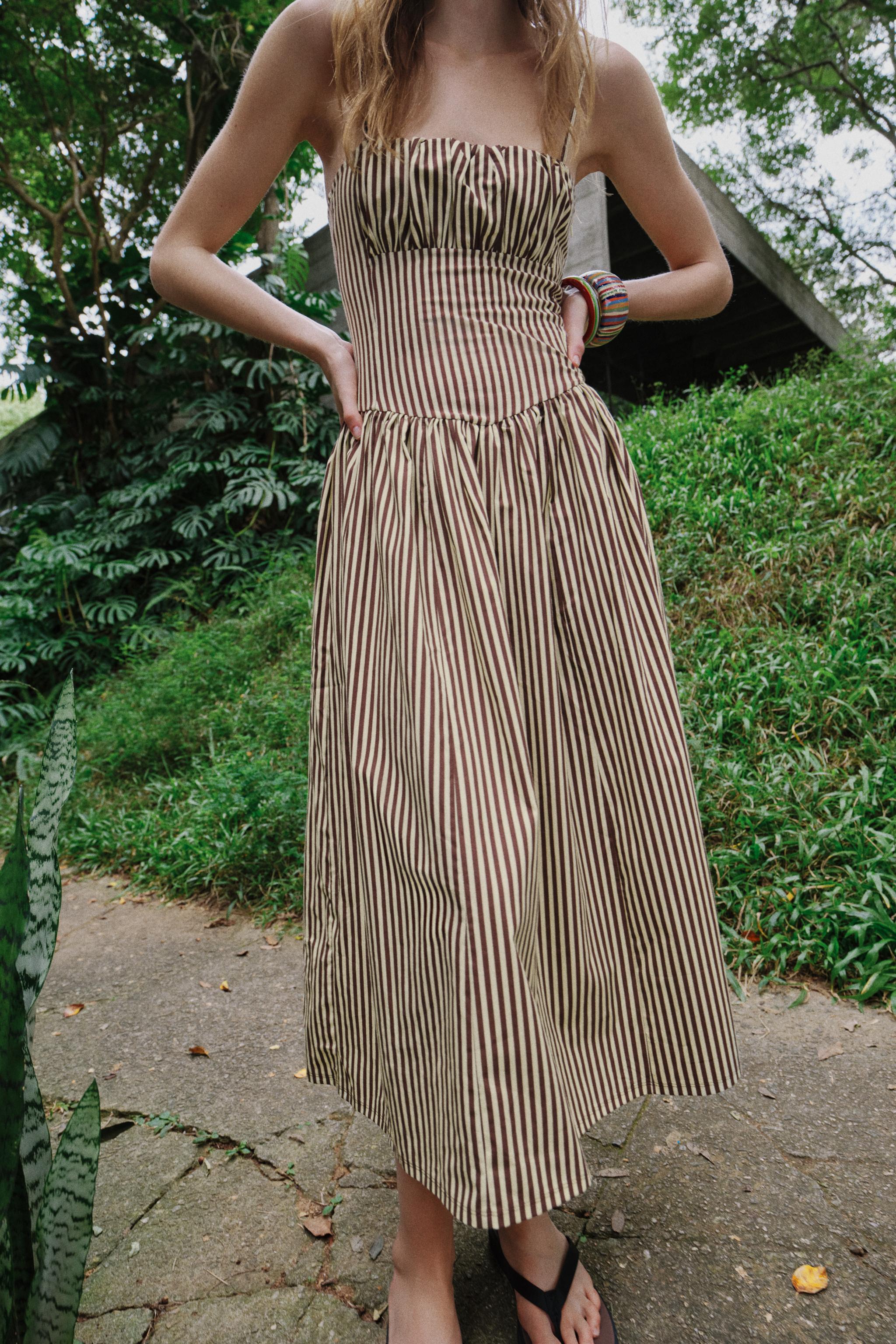 Striped Dress. With its sophisticated vertical stripes, flattering drop-waist silhouette,this piece is the ultimate choice for effortless, chic vacation style.