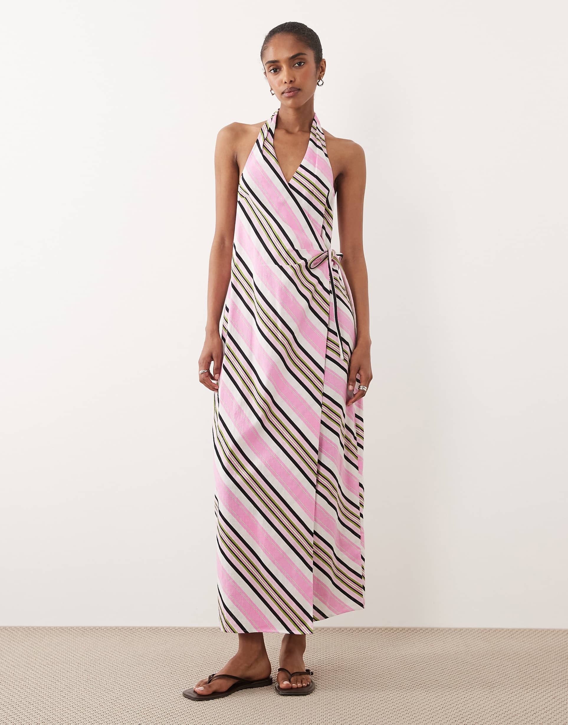 Featuring a sophisticated wrap silhouette, and a flattering halter neckline, this dress is the ultimate statement piece for elevated summer garden parties.