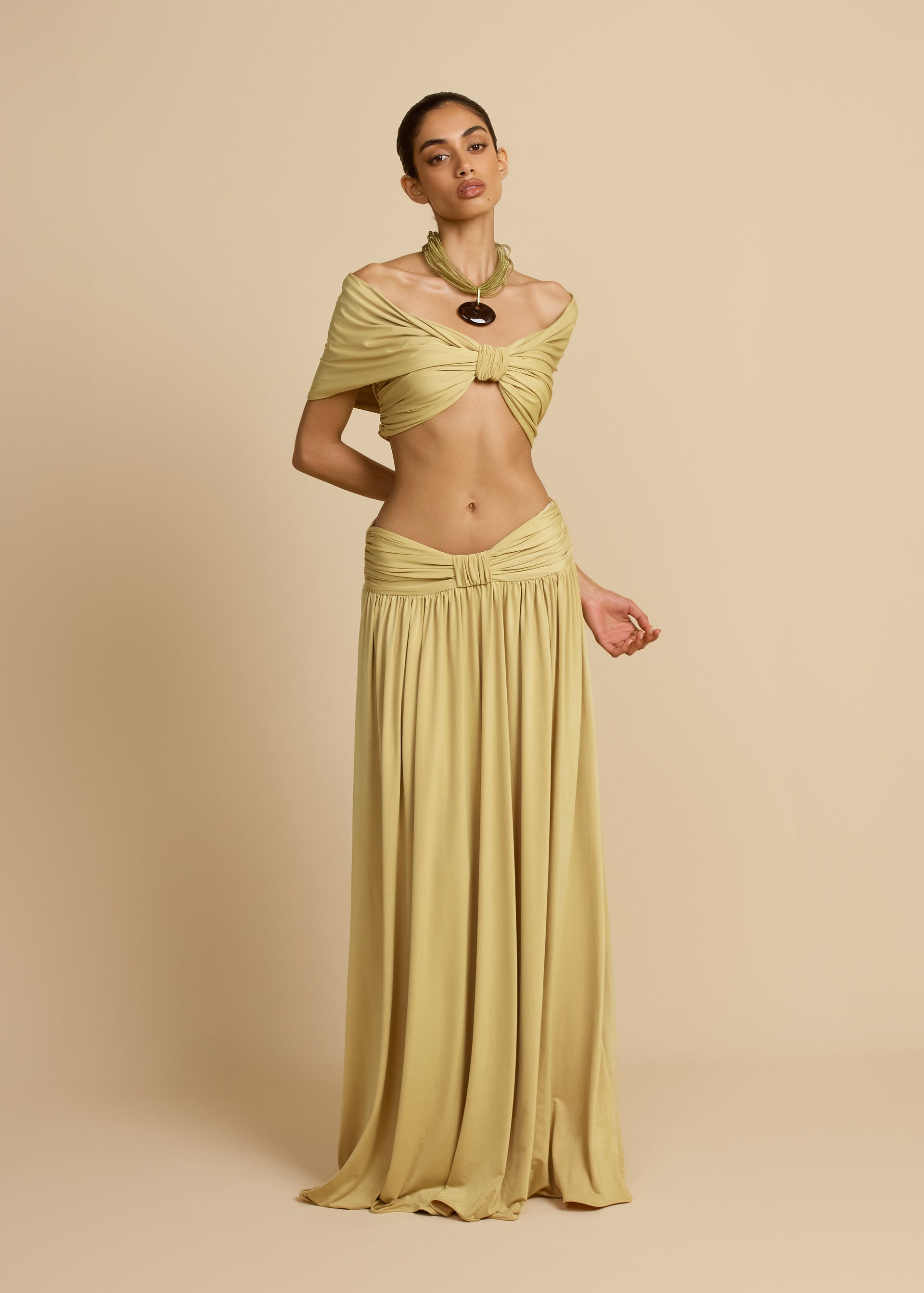 Featuring a sophisticated knot-front crop top, a dramatic draped maxi skirt, this set is the ultimate choice for elevated coastal getaways.