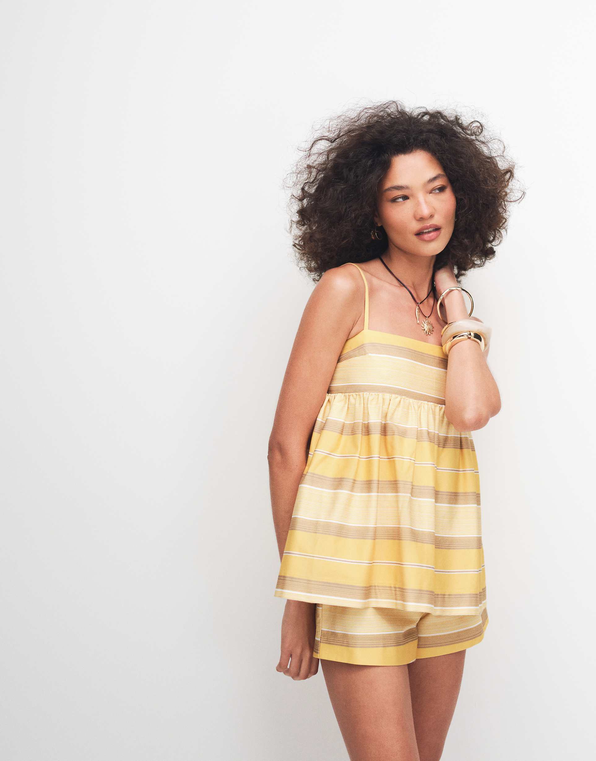 Featuring a cheerful yellow-and-white stripe, a flattering babydoll silhouette, this romper is your perfect go-to for beachside lounging.