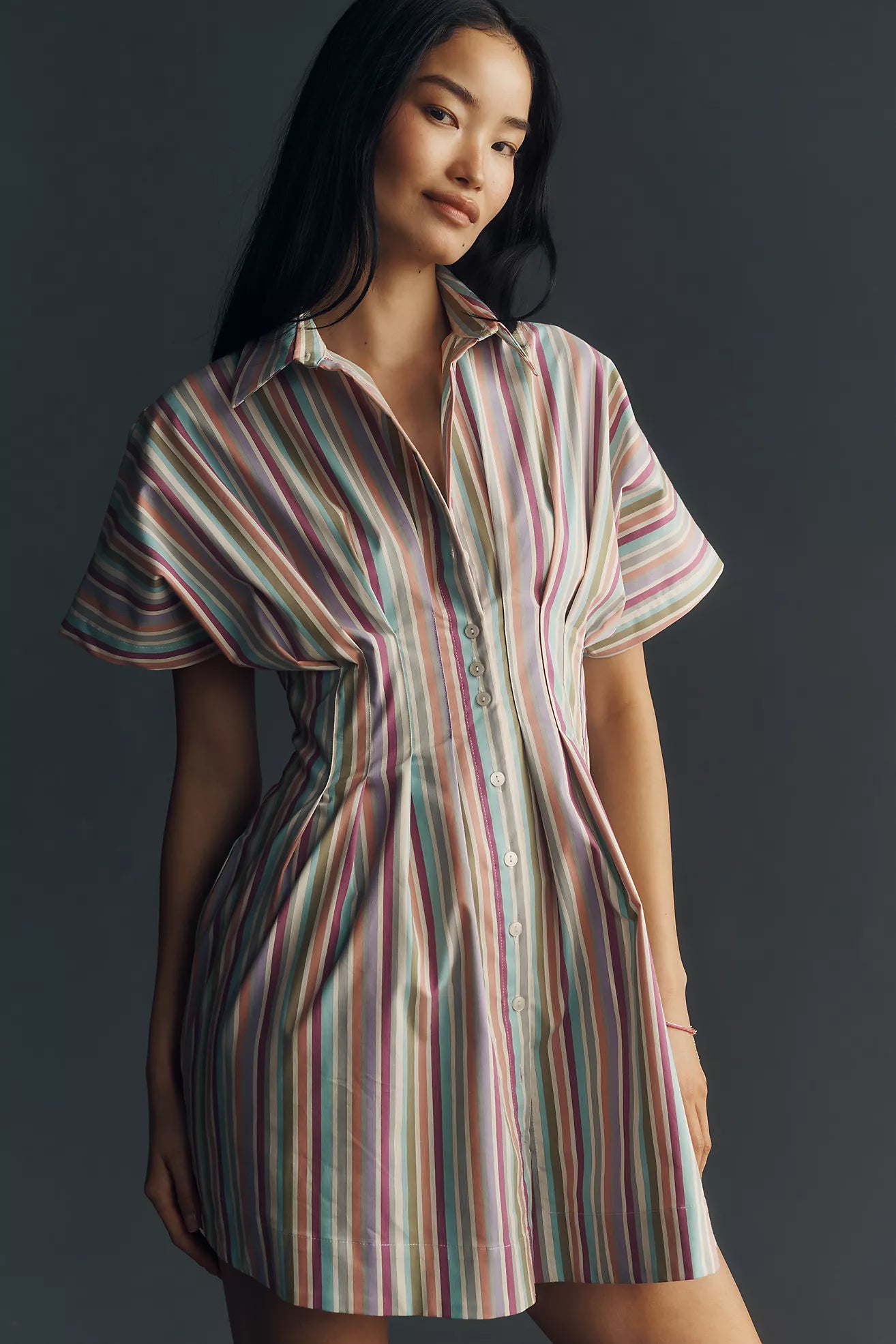 Multi-colored vertical stripe, a flattering tailored waist with pleating, this dress is the ultimate statement choice for sun-drenched coastal days.