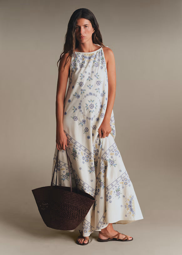 Featuring delicate blue botanical prints, this maxi is the ultimate statement choice for sun-drenched coastal getaways.
