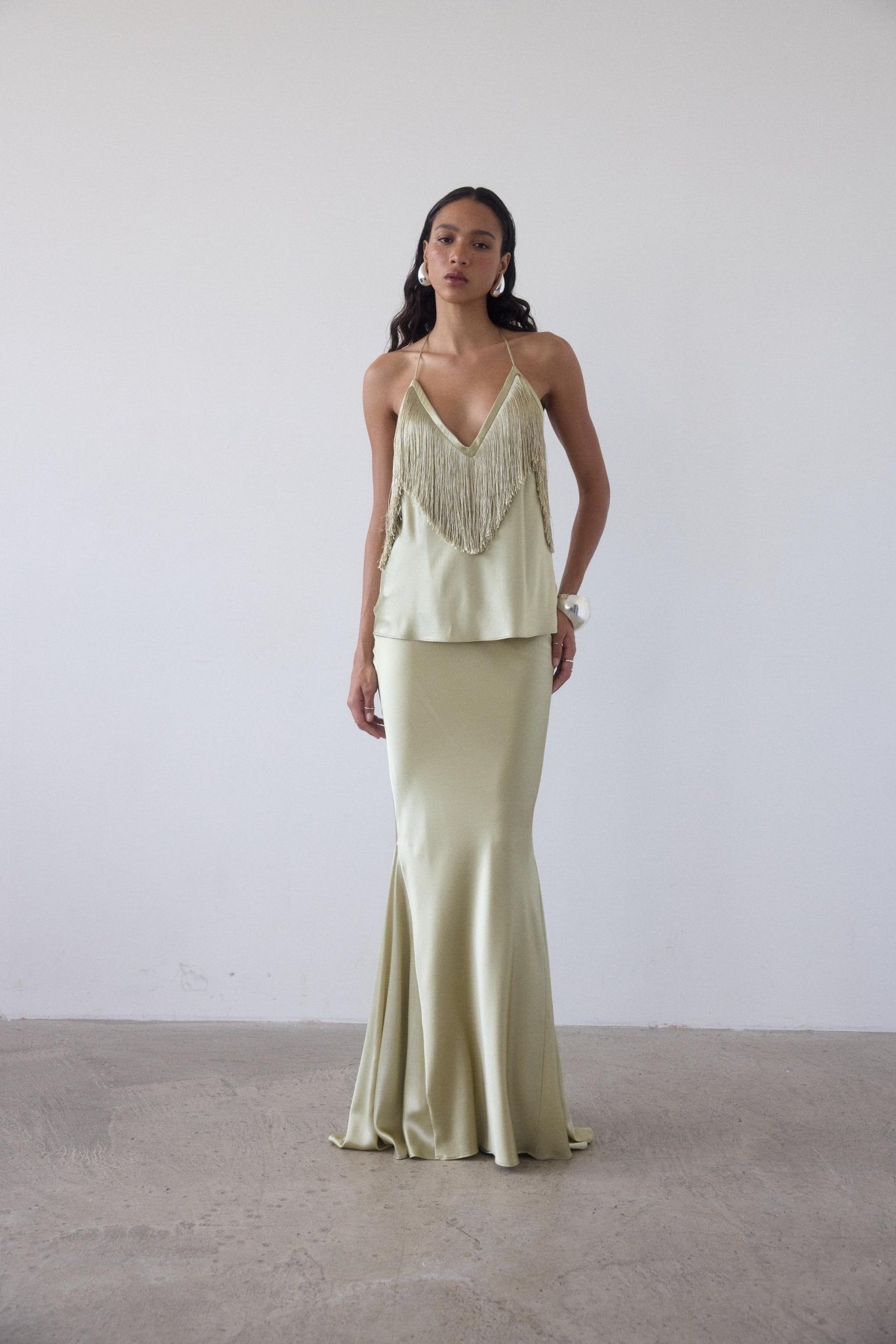 Featuring a dramatic fringed halter bodice, and a fluid bias-cut maxi skirt, this matching set is the ultimate statement piece for luxury resort getaways.