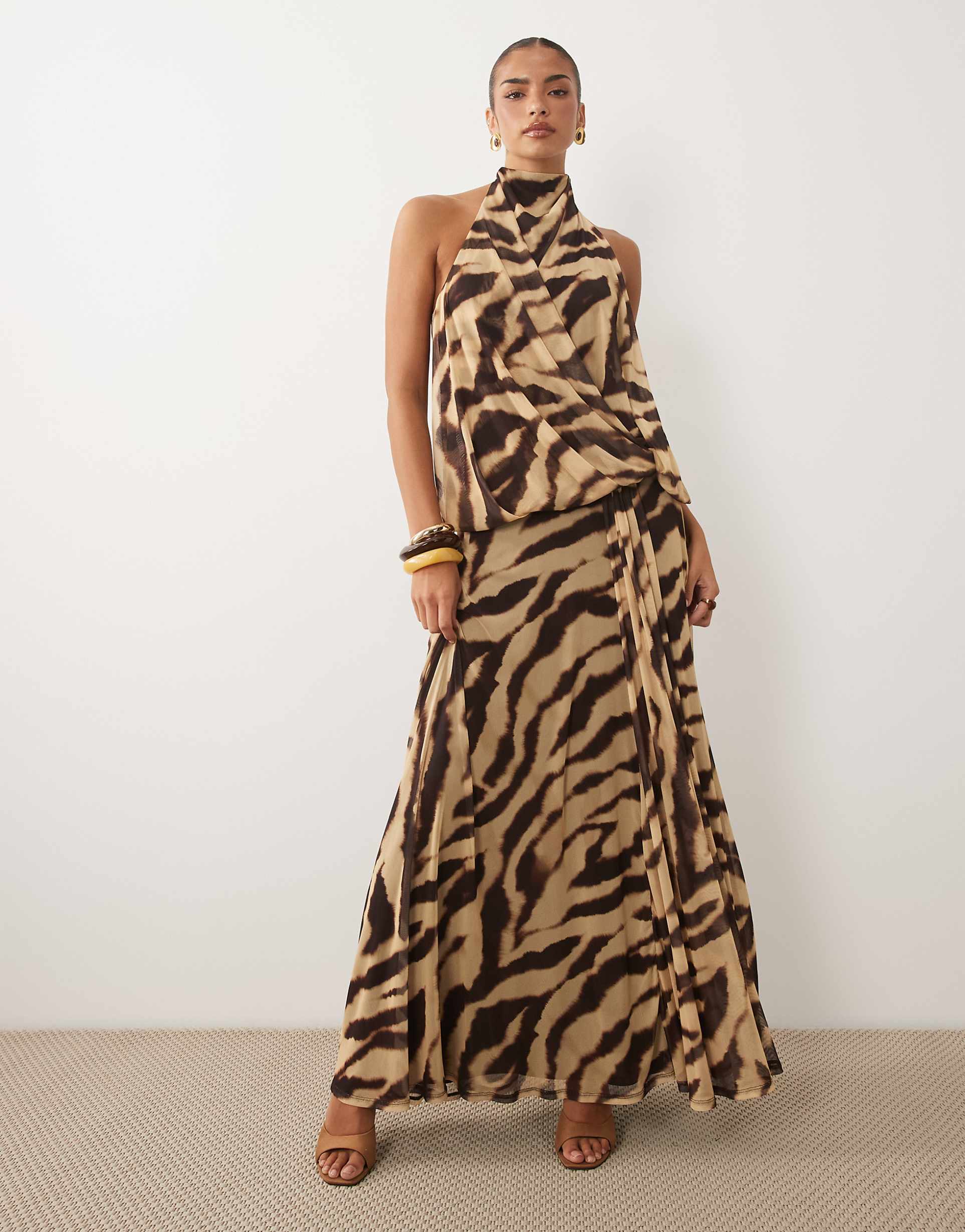 Featuring a striking neutral zebra animal print, this coordinated set is the ultimate statement piece for luxury resort getaways and glamorous evening soirées.