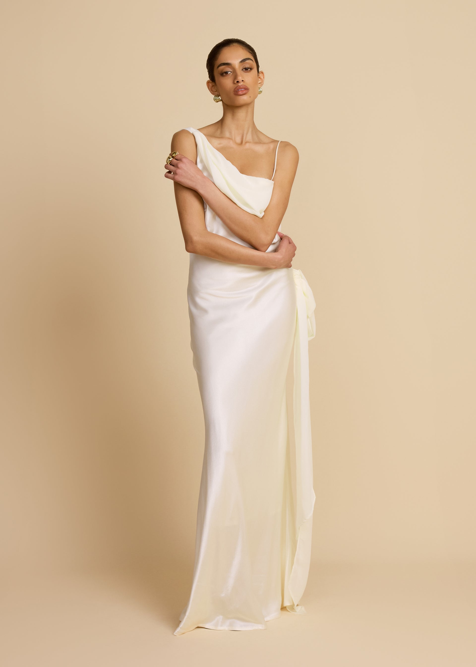 Featuring a satin finish,a dramatic asymmetric draped neckline with a delicate shoulder strap,this gown is the ultimate statement piece for luxury resort getaways.