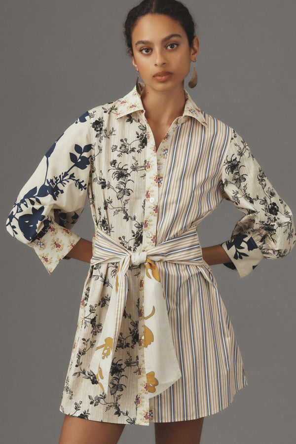 Featuring a  patchwork design combining botanical florals,a shirt collar, balloon sleeves, this mini dress is the ultimate statement piece for resort getaways.