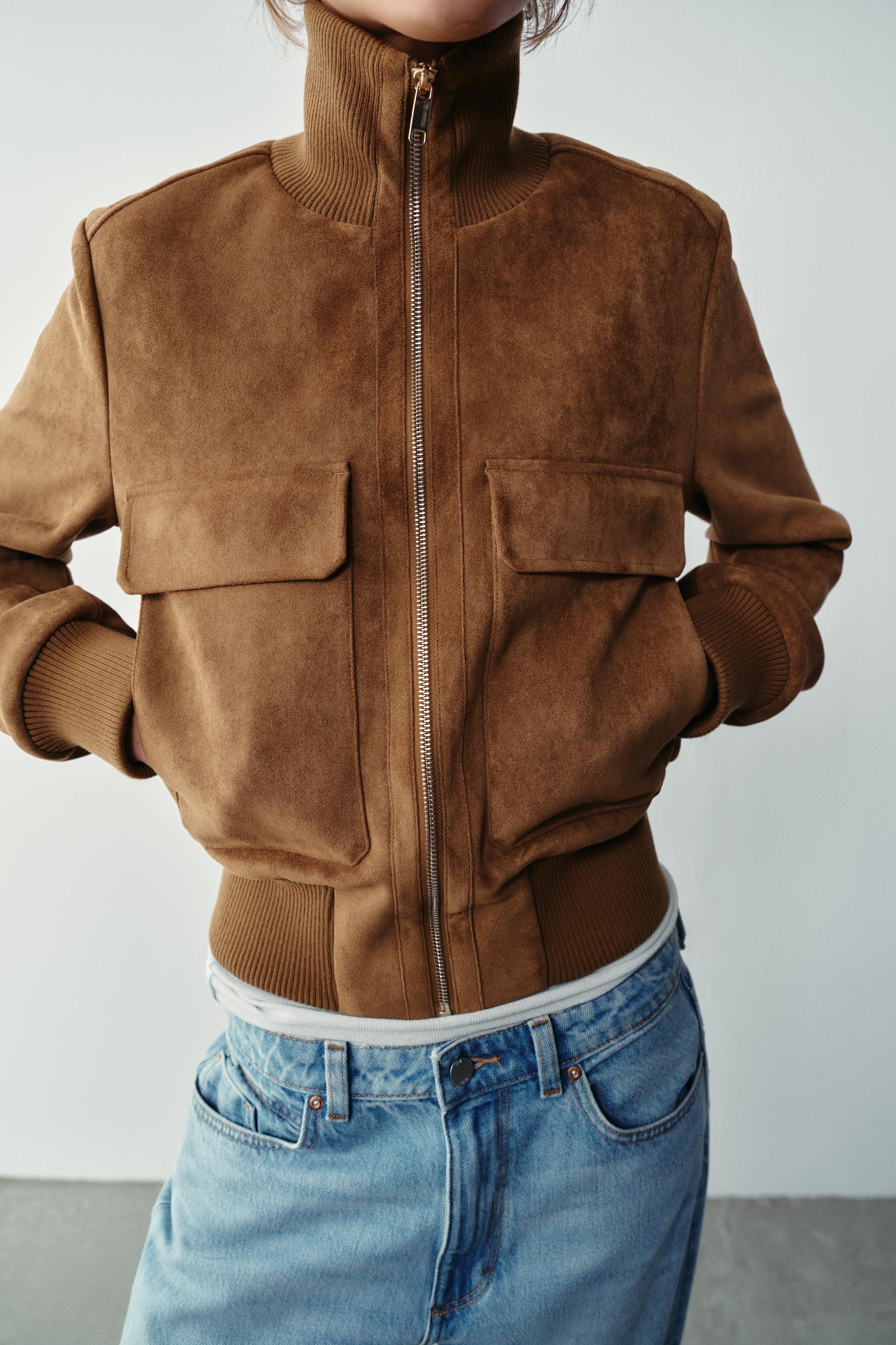 Featuring a structured mock neckline with a polished gold-tone zipper, dual chest flap pockets,this is the ultimate statement piece for transitional layering.
