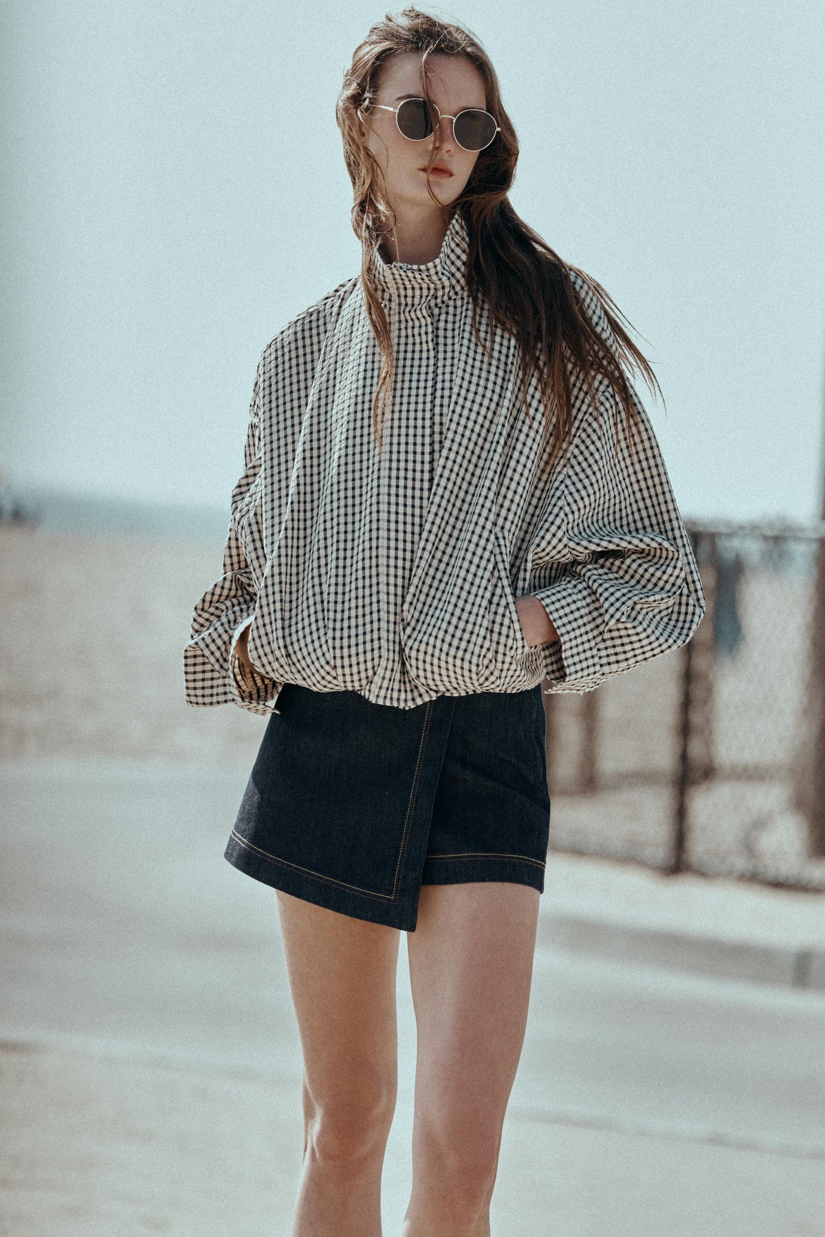 Featuring a classic gingham check pattern, a structured mock neckline, drop shoulders,this jacket is the ultimate statement piece for cool coastal getaways.