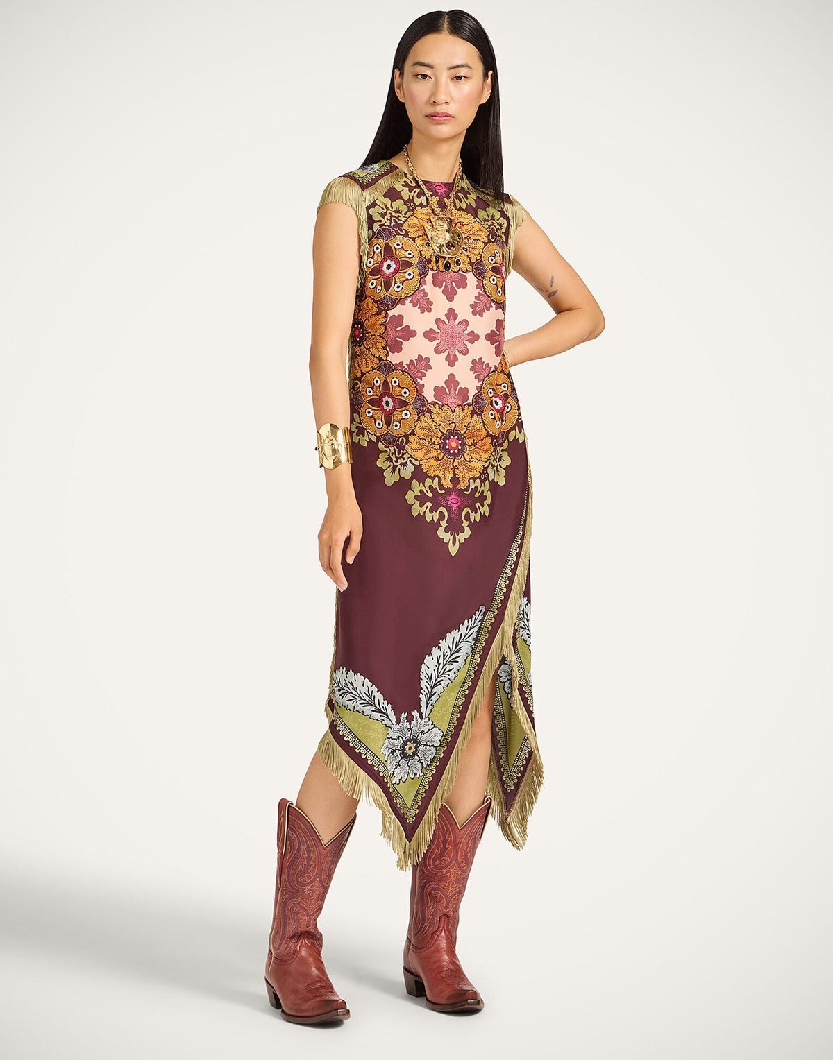 Featuring a floral motifs,and delicate fringe-trimmed asymmetrical hems, this dress is the ultimate statement piece for luxury resort getaways.