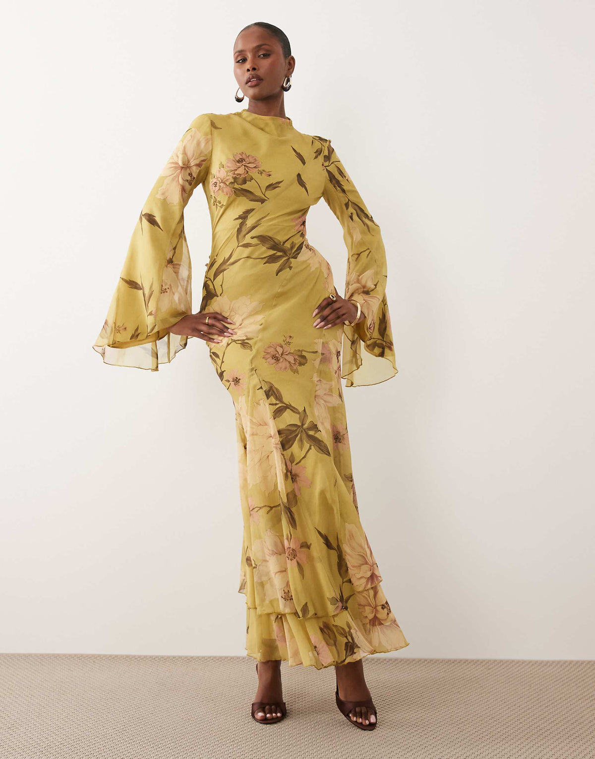 Featuring a watercolor floral prints, a sophisticated neckline, dramatic flared bell sleeves,this dress is the ultimate statement piece for luxury resort getaways.