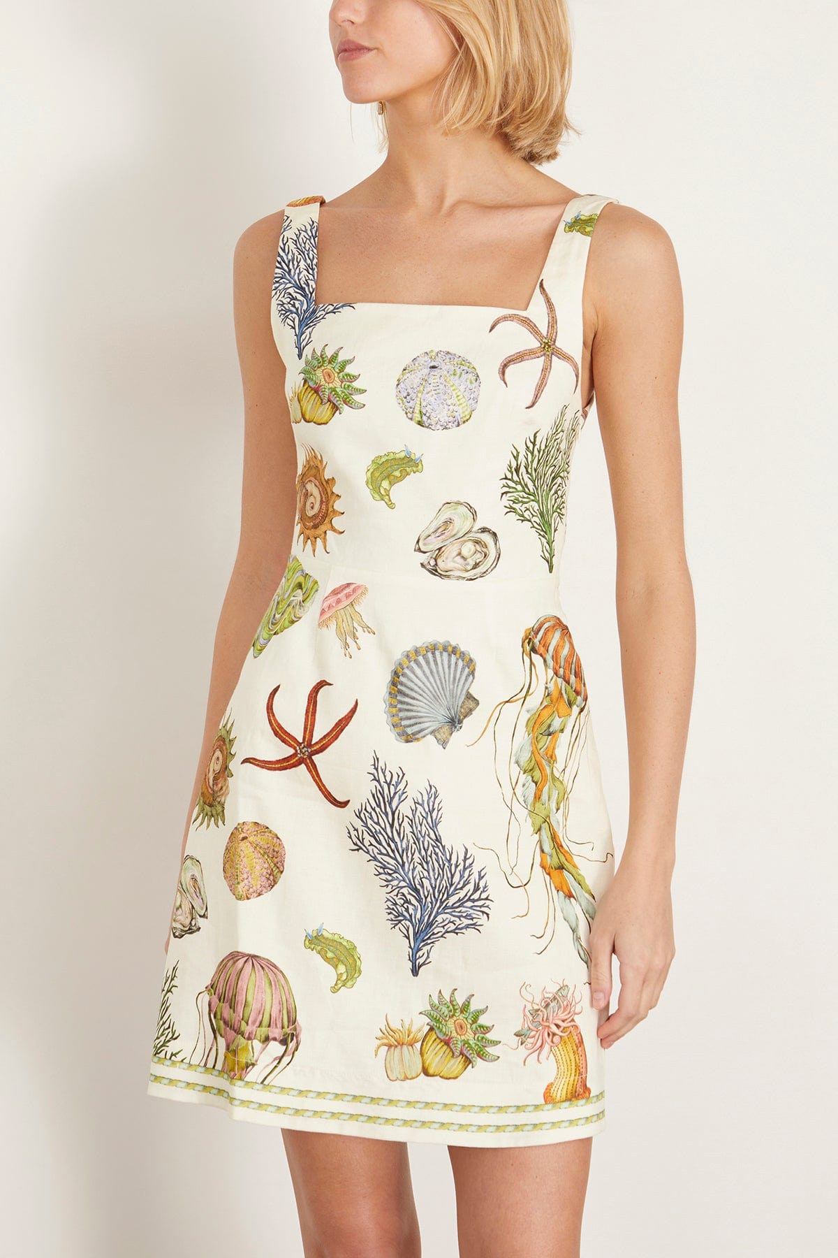 Featuring a detailed illustrations of seashells, starfish, a clean square neckline,this dress is the ultimate statement piece for luxury resort getaways.