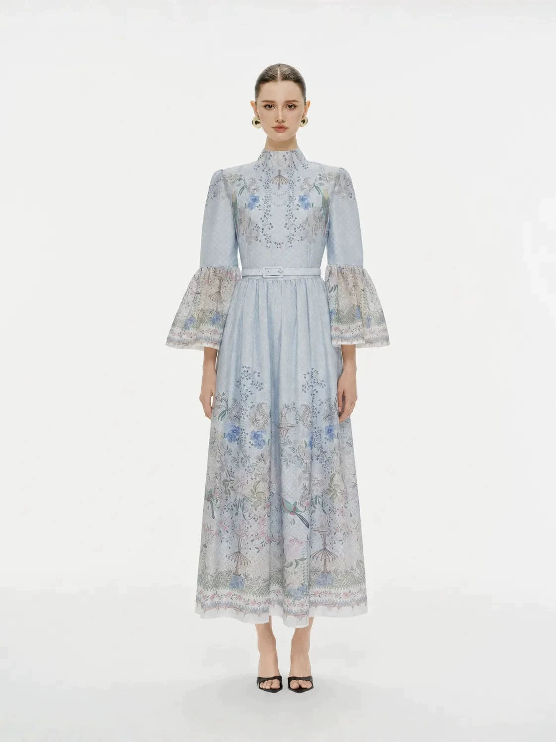 Featuring a intricate botanical floral prints, a high mock neckline, sheer bell sleeves,this dress is the ultimate statement piece for luxury resort getaways.