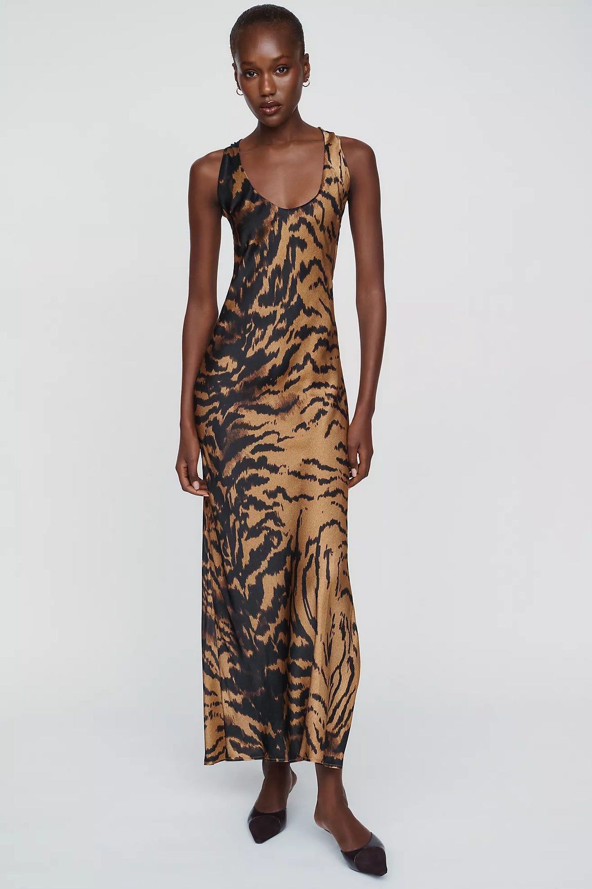 Featuring a striking brown and black tiger animal print, a classic scoop neckline,this dress is the ultimate statement piece for luxury resort getaways.