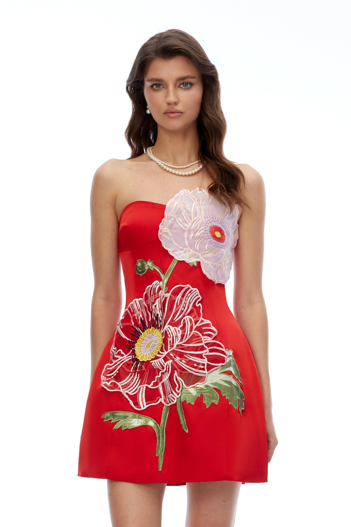 Featuring a striking 3D red and pink floral appliqués and intricate embroidered stems, this dress is the ultimate statement piece for luxury resort getaways.