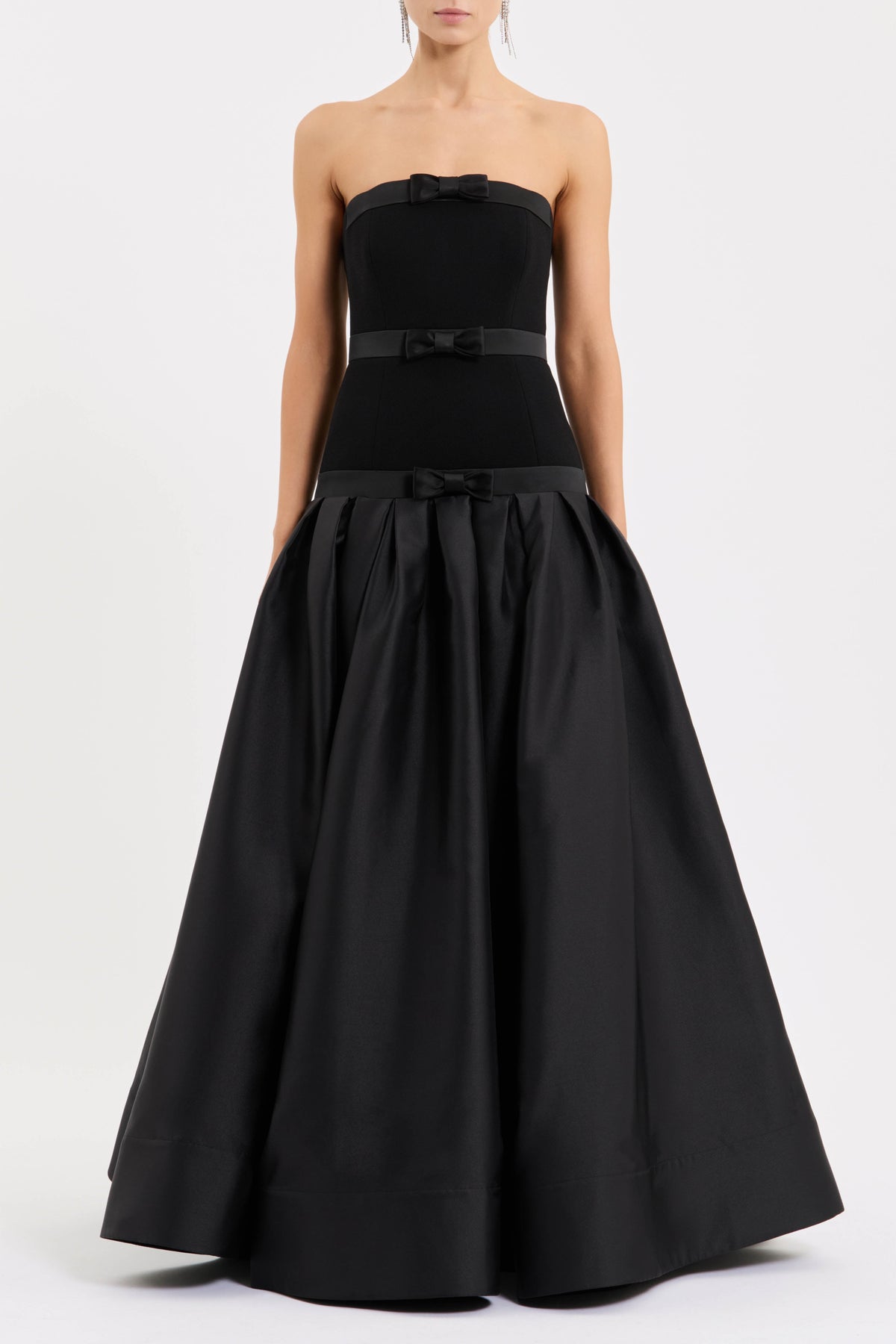 Featuring delicate mini bow accents along the neckline, waist, and dropped waistline, this dress is the ultimate statement piece for luxury resort getaways.