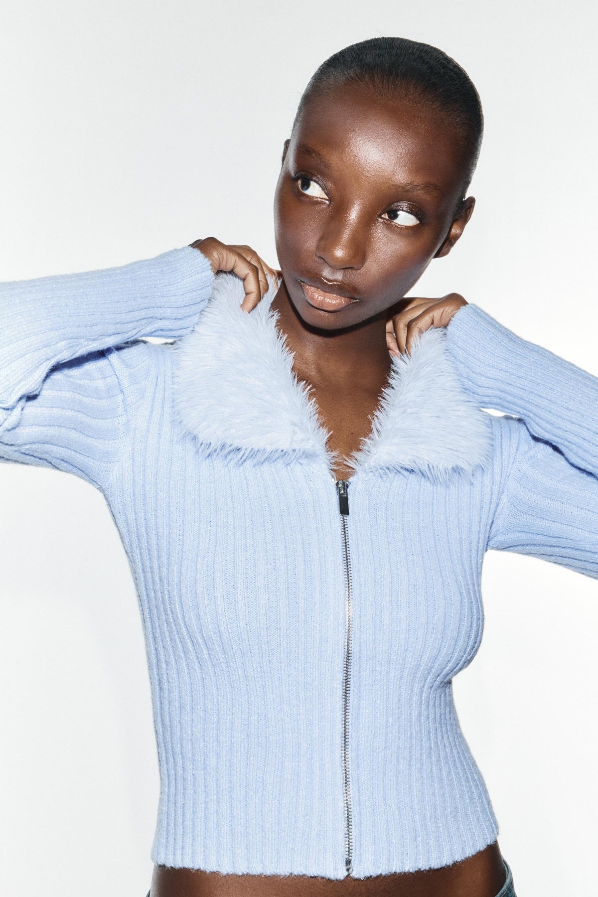Featuring a plush matching faux-fur collar, a full front zipper, this sweater is the ultimate statement piece for luxury resort getaways.