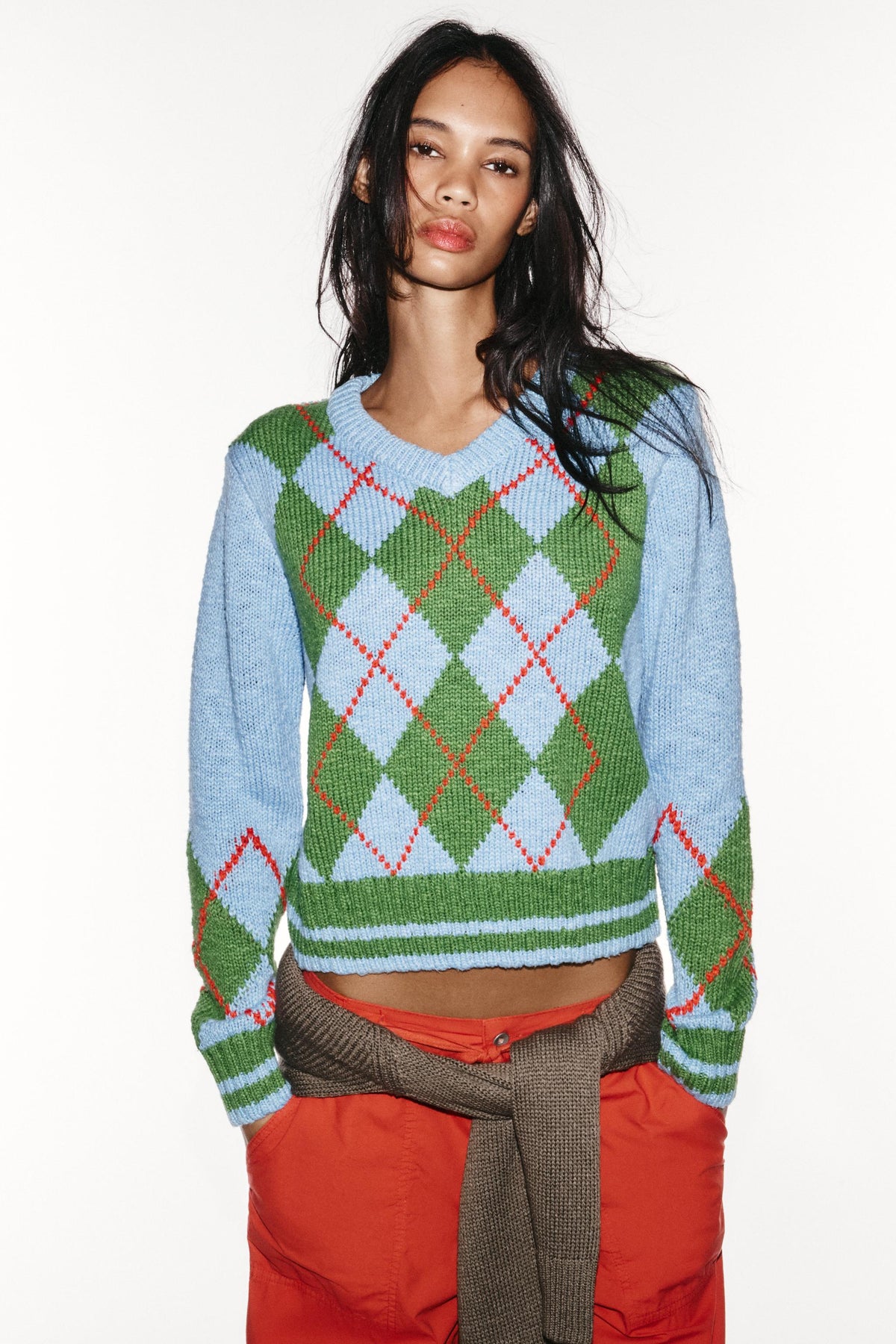 Featuring a delicate red lines, a classic V-neckline, and a cozy relaxed silhouette, this sweater is the ultimate statement piece for luxury resort getaways.