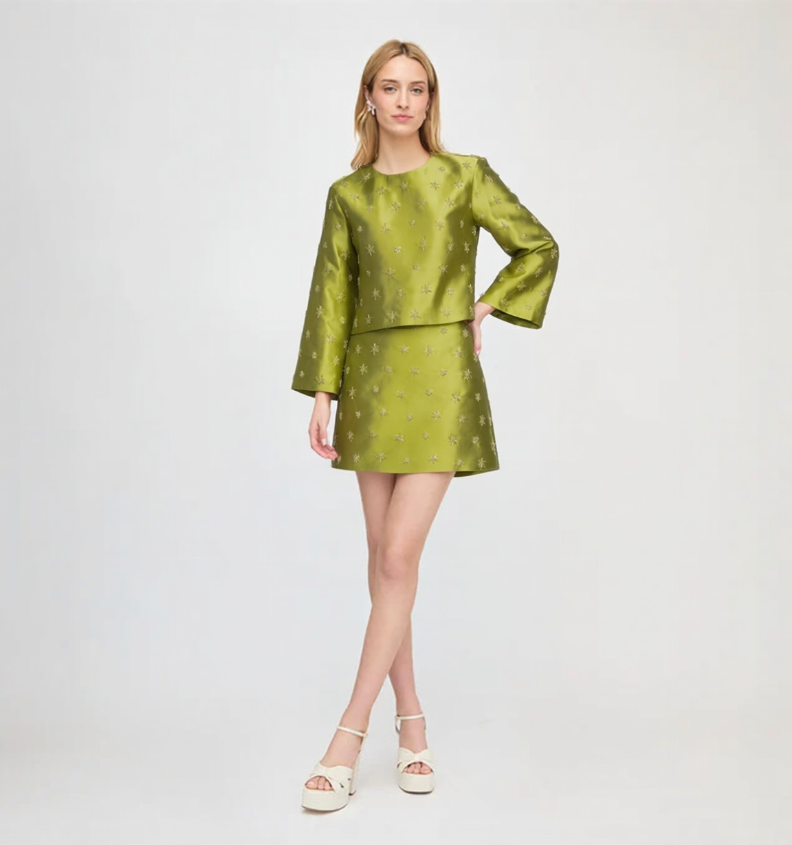 Featuring a shimmering embroidery, a crewneck crop top, and a matching mini skirt, this two-piece set is the ultimate statement piece for luxury resort getaways.