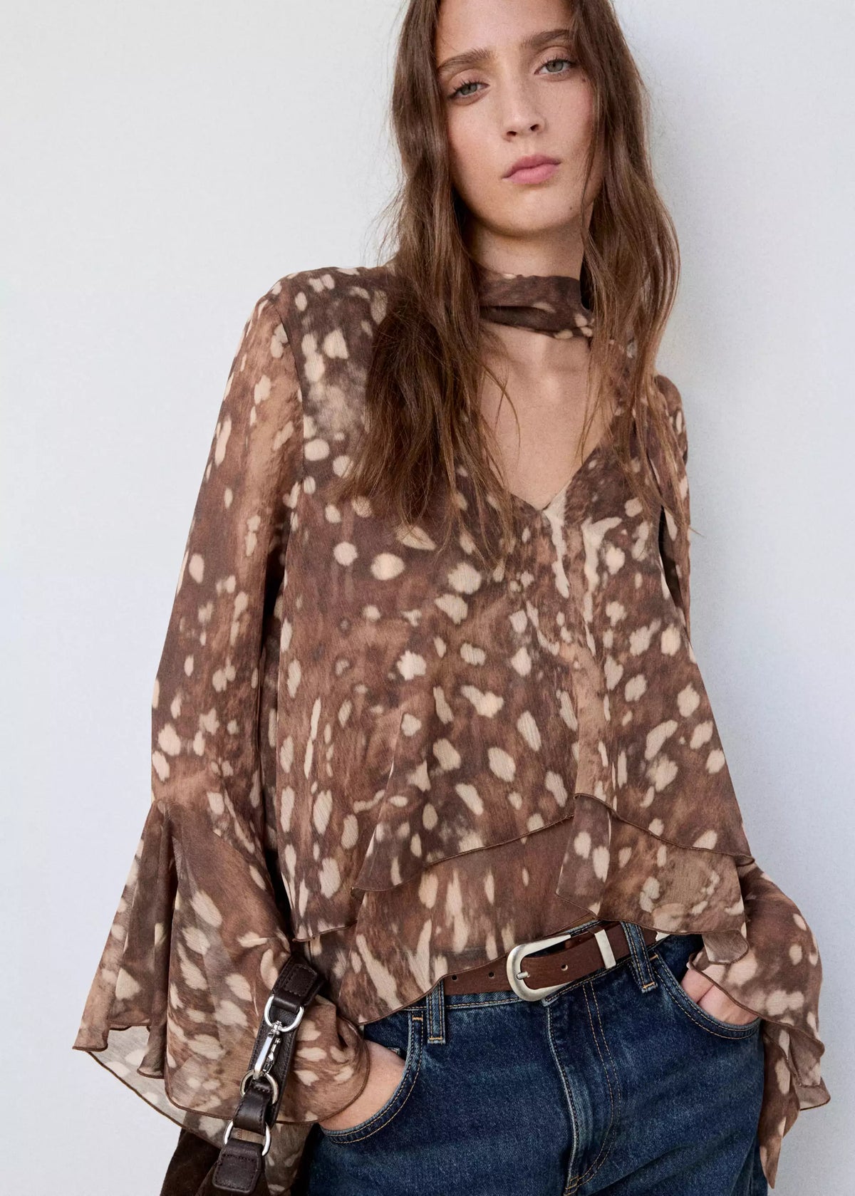 Featuring a graceful V-neckline, and dramatic tiered flared sleeves, this blouse is the ultimate statement piece for luxury resort getaways.