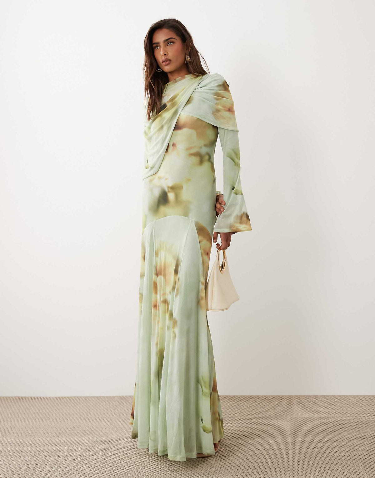 Elevate Long-Sleeve Draped Watercolor Maxi Dress. Features rich abstract floral details, asymmetrical shoulder drape, and a sweeping hem.